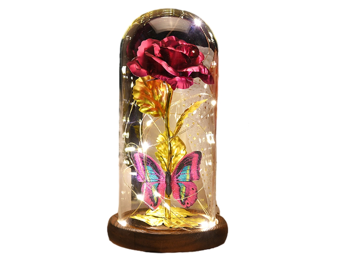 Lámpara de oro rosa con LED y pétalos caídos bajo una cúpula de cristal sobre una base de madera