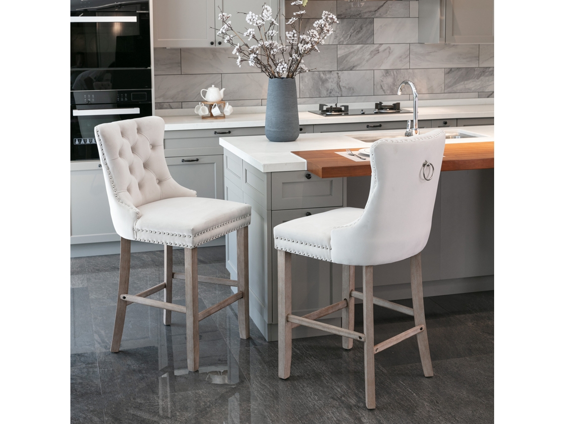 Par De Taburetes De Bar Beige Capitoné Con Patas De Madera Y Tachuelas.