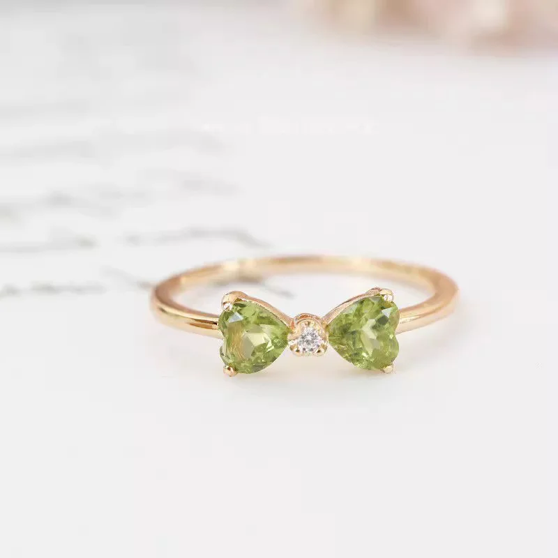 Un Elegante Anillo De Oro Con Forma De Lazo Engastado Con Una Circonita Cúbica Cuadrada Verde Sencillo Y Versátil.
