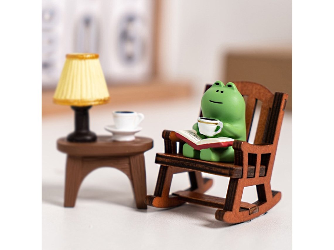 Figuras de ranas en miniatura con decoración de mecedora.