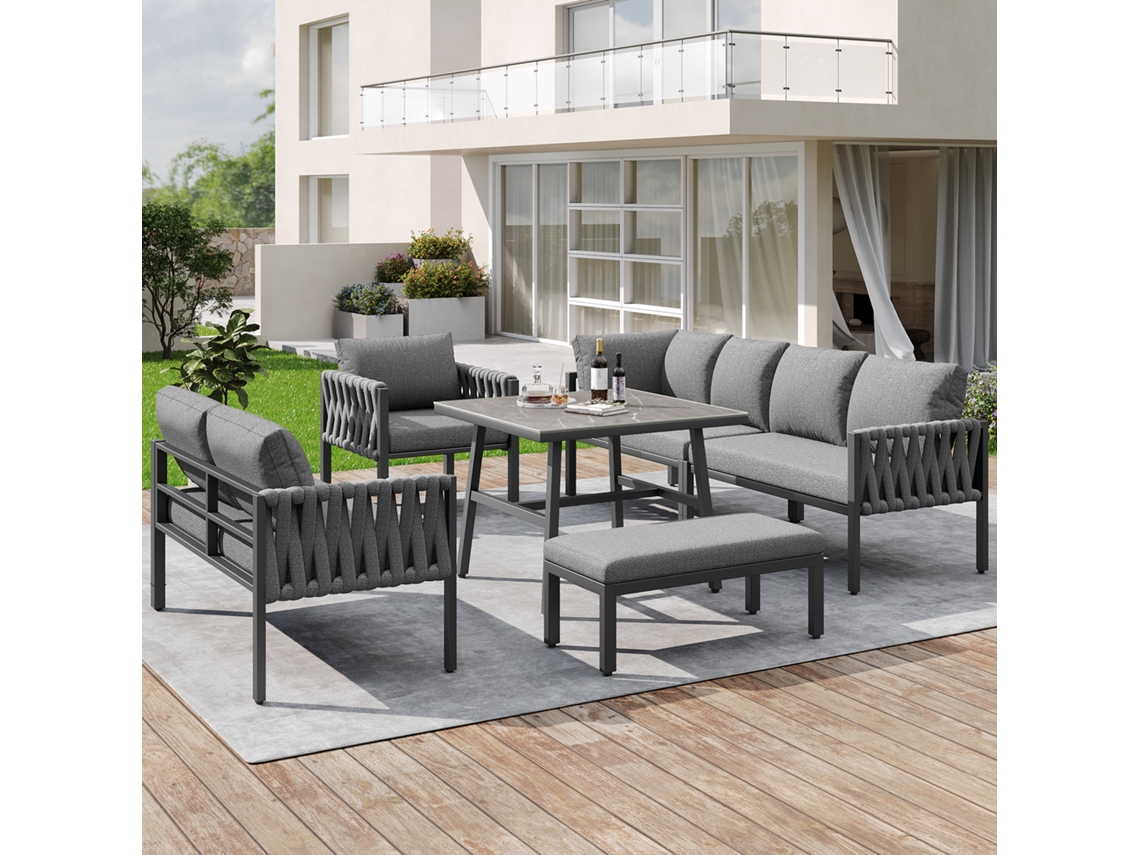 Conjunto de jardín con sofá esquinero, mesa de cristal, patas ajustables y cojines.