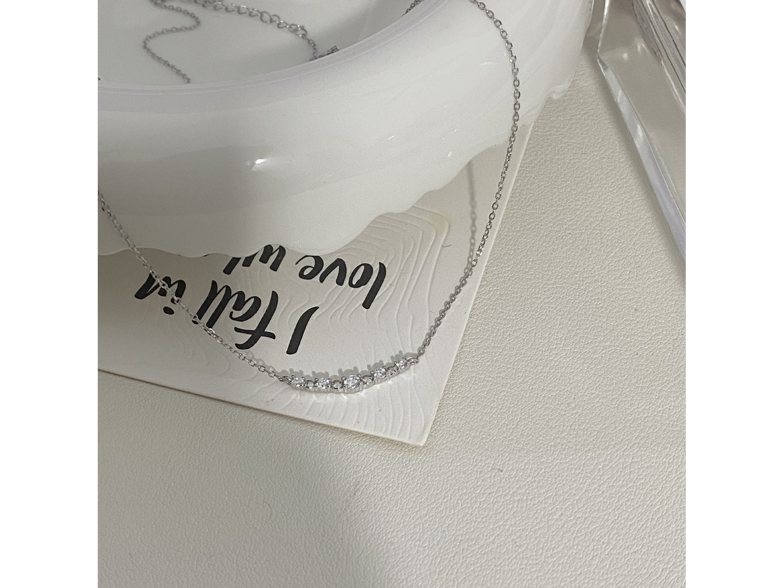 Fotografía real de un ambiente elegante y sofisticado, plata de ley 925, collar sonriente, lujo discreto y versátil. MDUG (oro blanco)